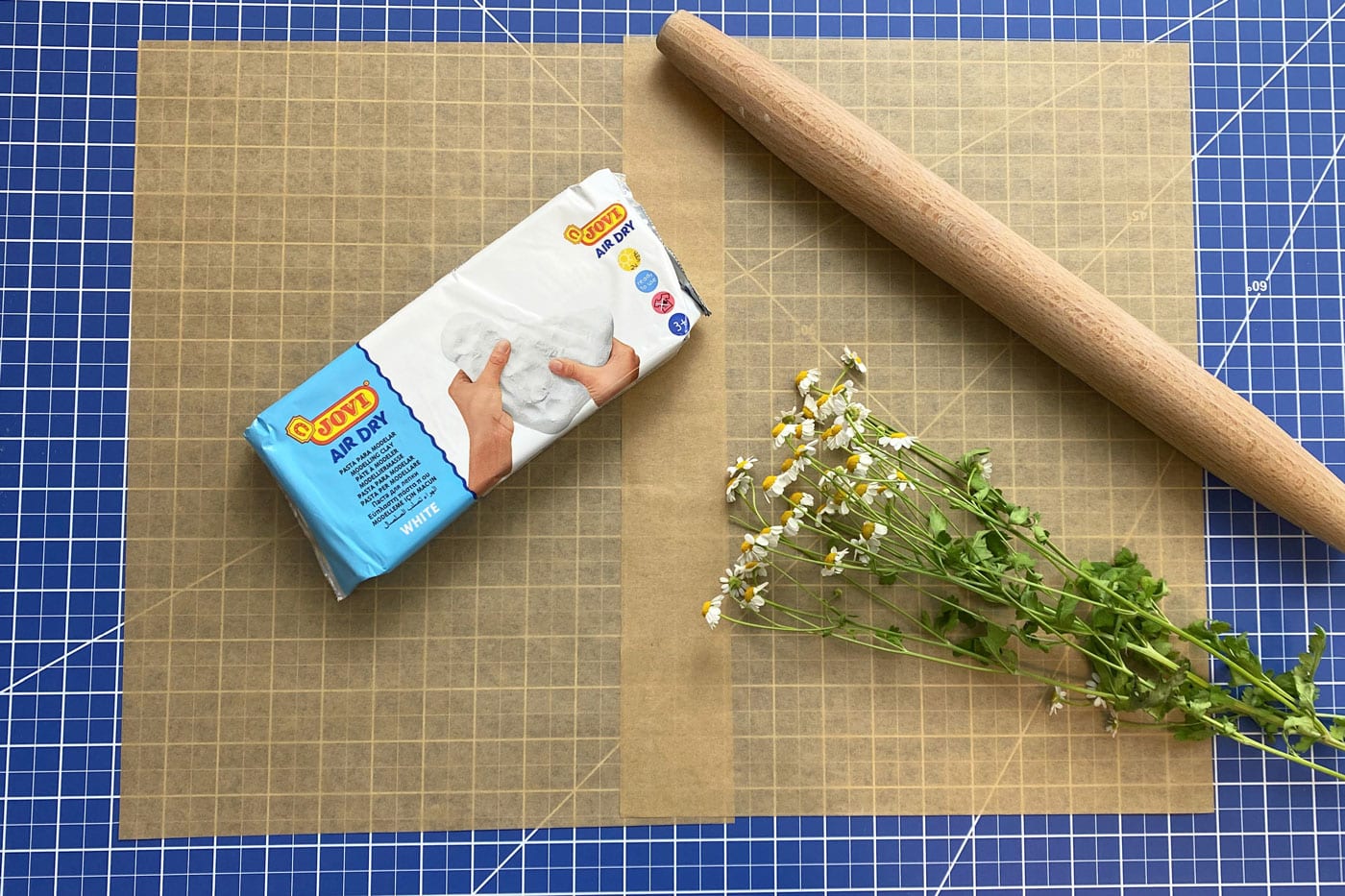 paquet d'argile, rouleau à pâtisserie et fleurs sur papier brun