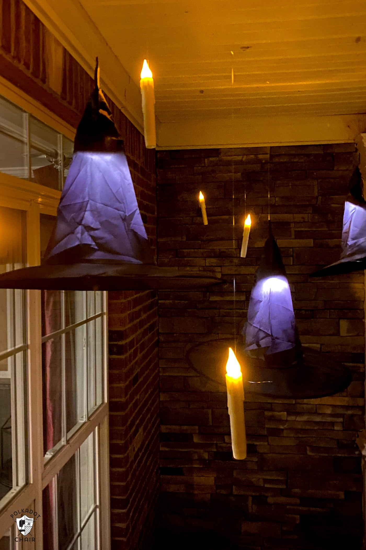 Bougies LED flottant sur le porche avec des chapeaux de sorcière noirs la nuit