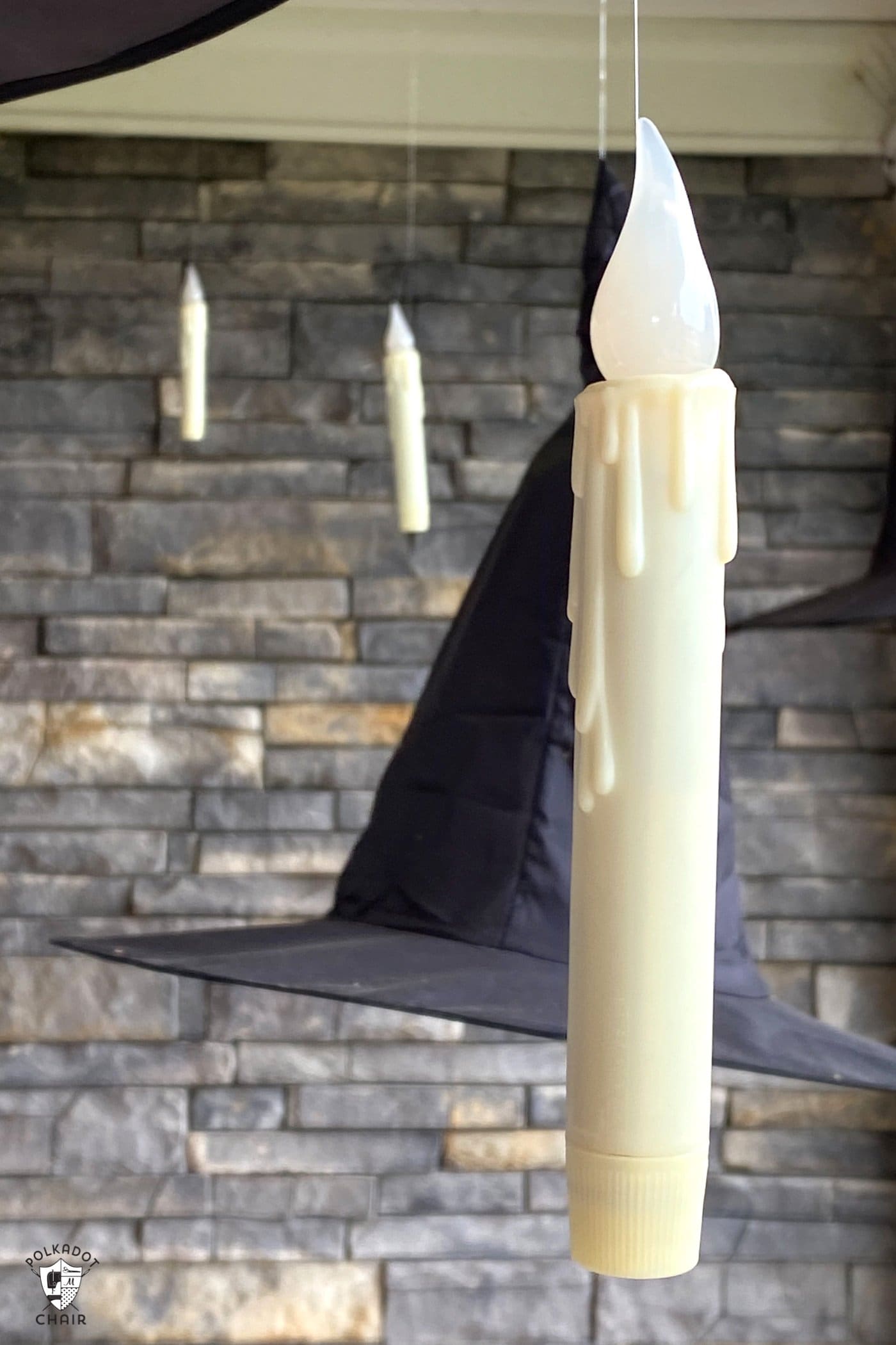 Bougies LED flottant sur le porche avec des chapeaux de sorcière noirs
