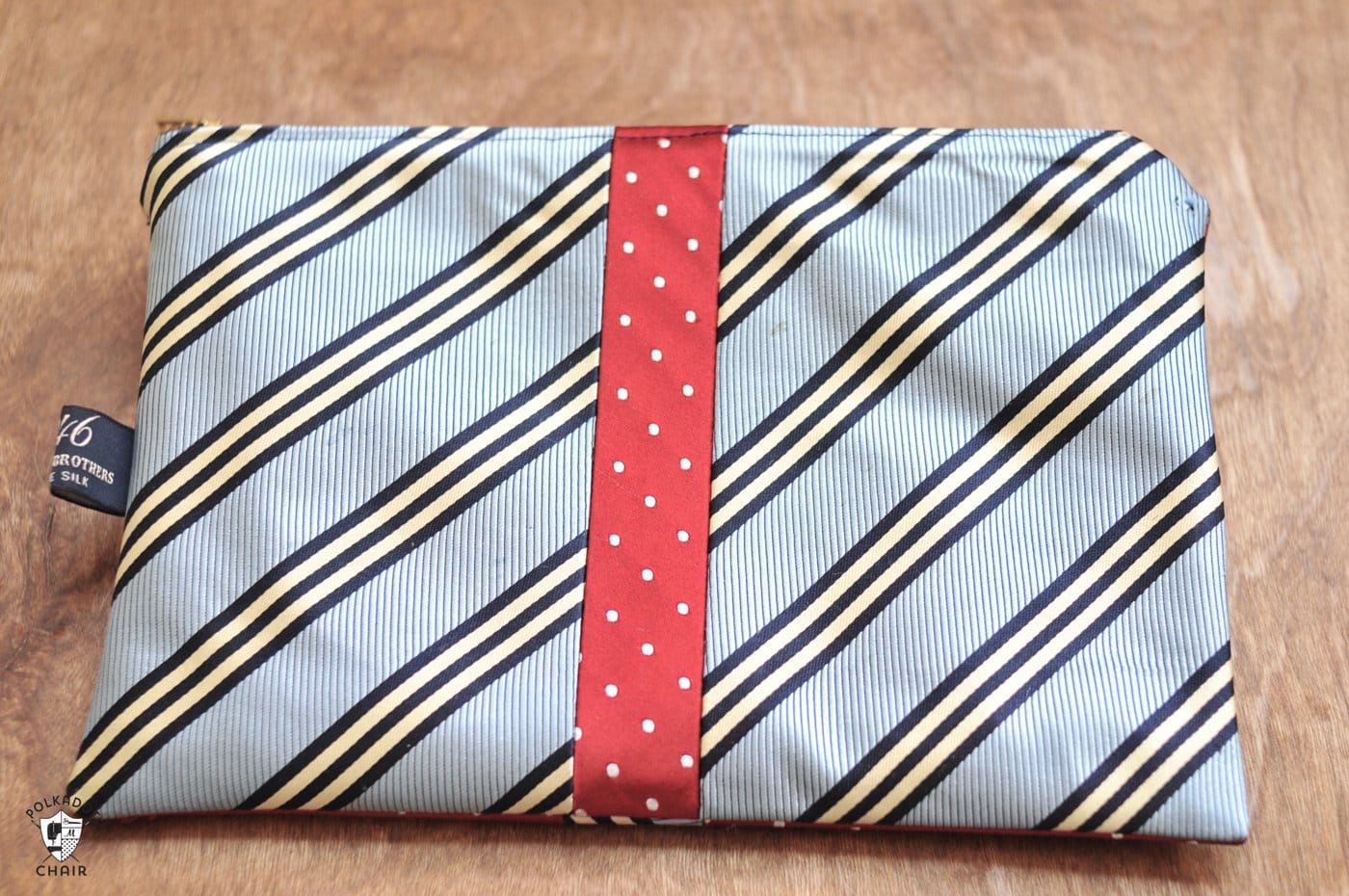 Pochette zippée à cravate recyclée sur table marron
