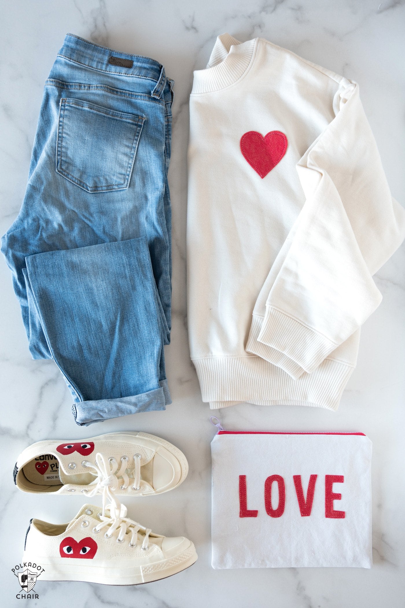 sweat-shirt ivoire, jeans et chaussures sur table blanche