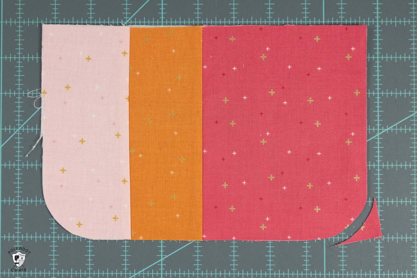 couper des morceaux de tissu rose et orange sur un tapis de découpe