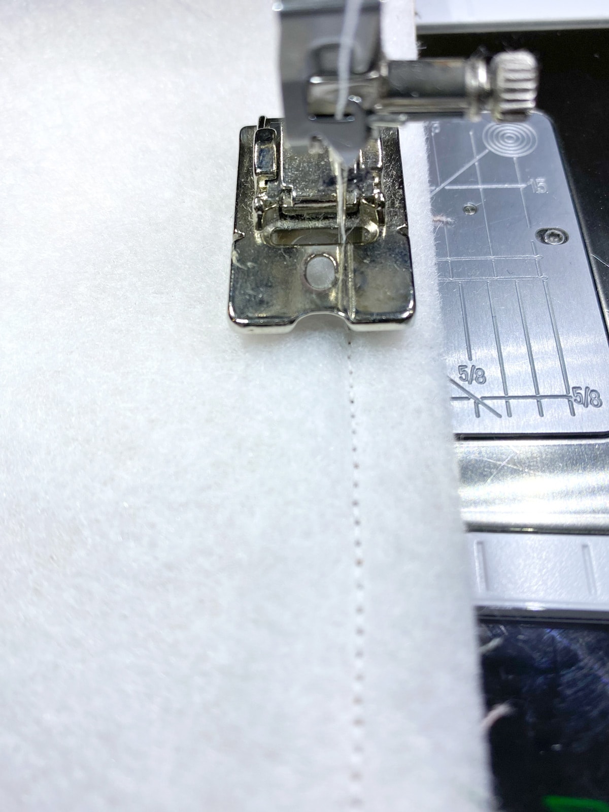 gros plan du pied de machine à coudre sur l'interface de couture de machine