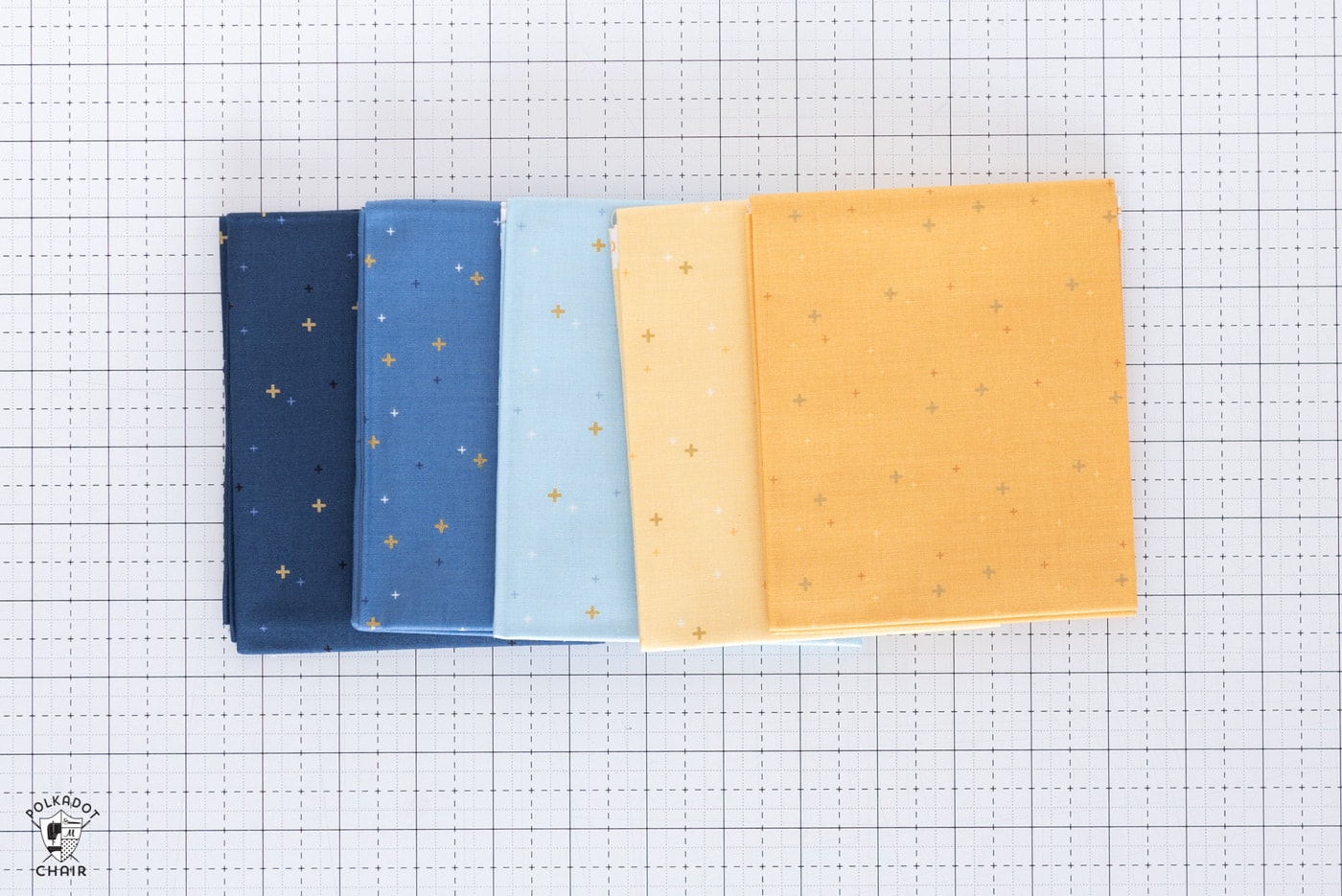 pile de tissus pliés colorés sur un tapis de découpe blanc