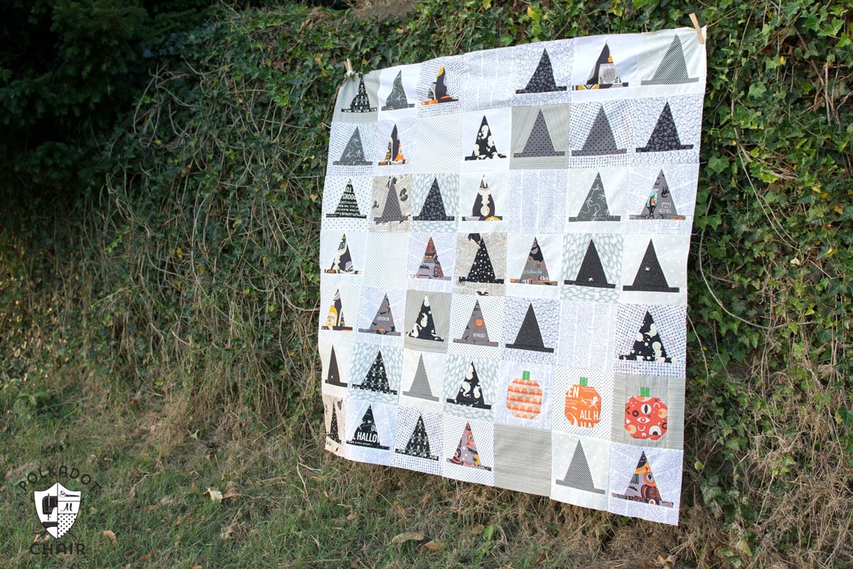 La courtepointe de mercerie d'Halloween ; un projet amusant de couture et de courtepointe pour Halloween comprenant des rangées de blocs de courtepointe en forme de chapeau de sorcière.
