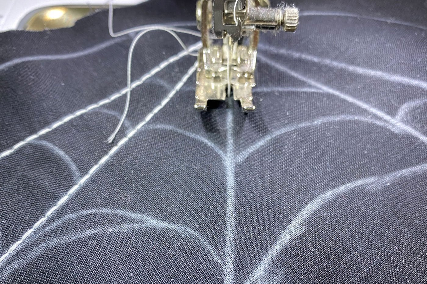 Machine à coudre cousant des lignes droites sur un tissu noir