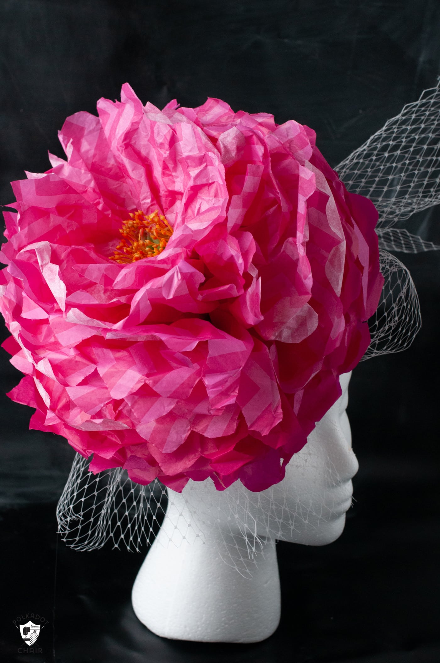 fascinator fleur en papier rose sur tête blanche sur fond noir