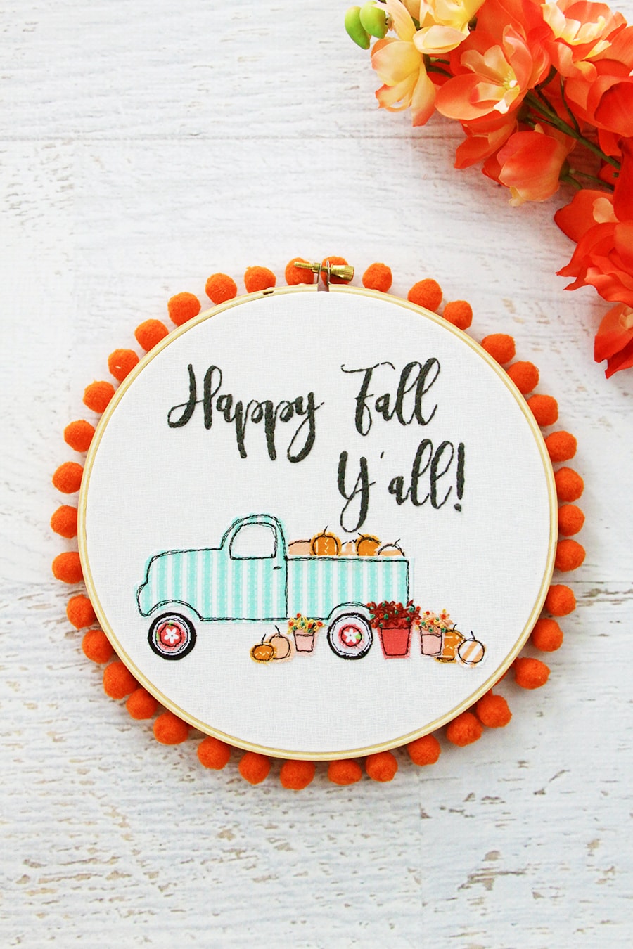 Art de cerceau de broderie d'automne avec des motifs de camions et de citrouilles avec bordure à pompons.