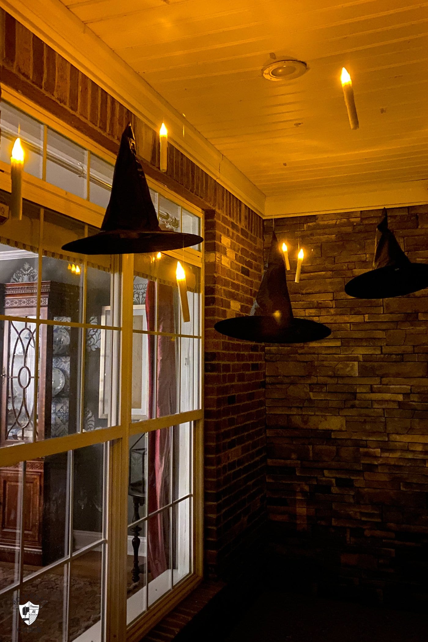 Bougies LED flottant sur le porche avec des chapeaux de sorcière noirs la nuit