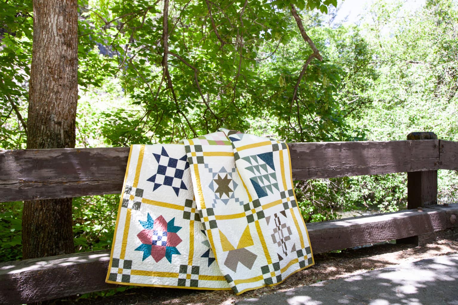 kleurrijke quilt gedrapeerd op een houten hek buiten