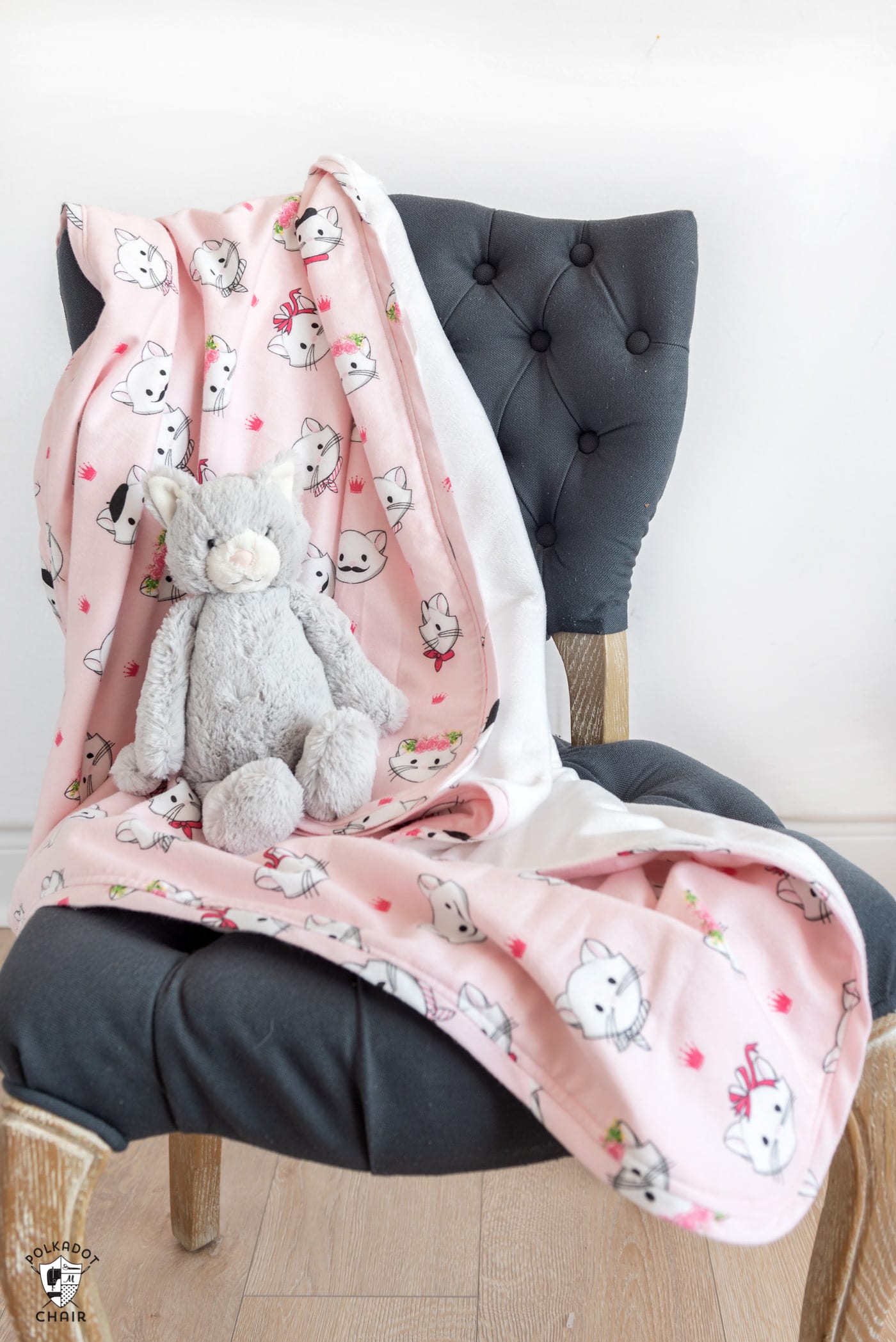 couverture de flanelle rose sur chaise grise avec chat jouet