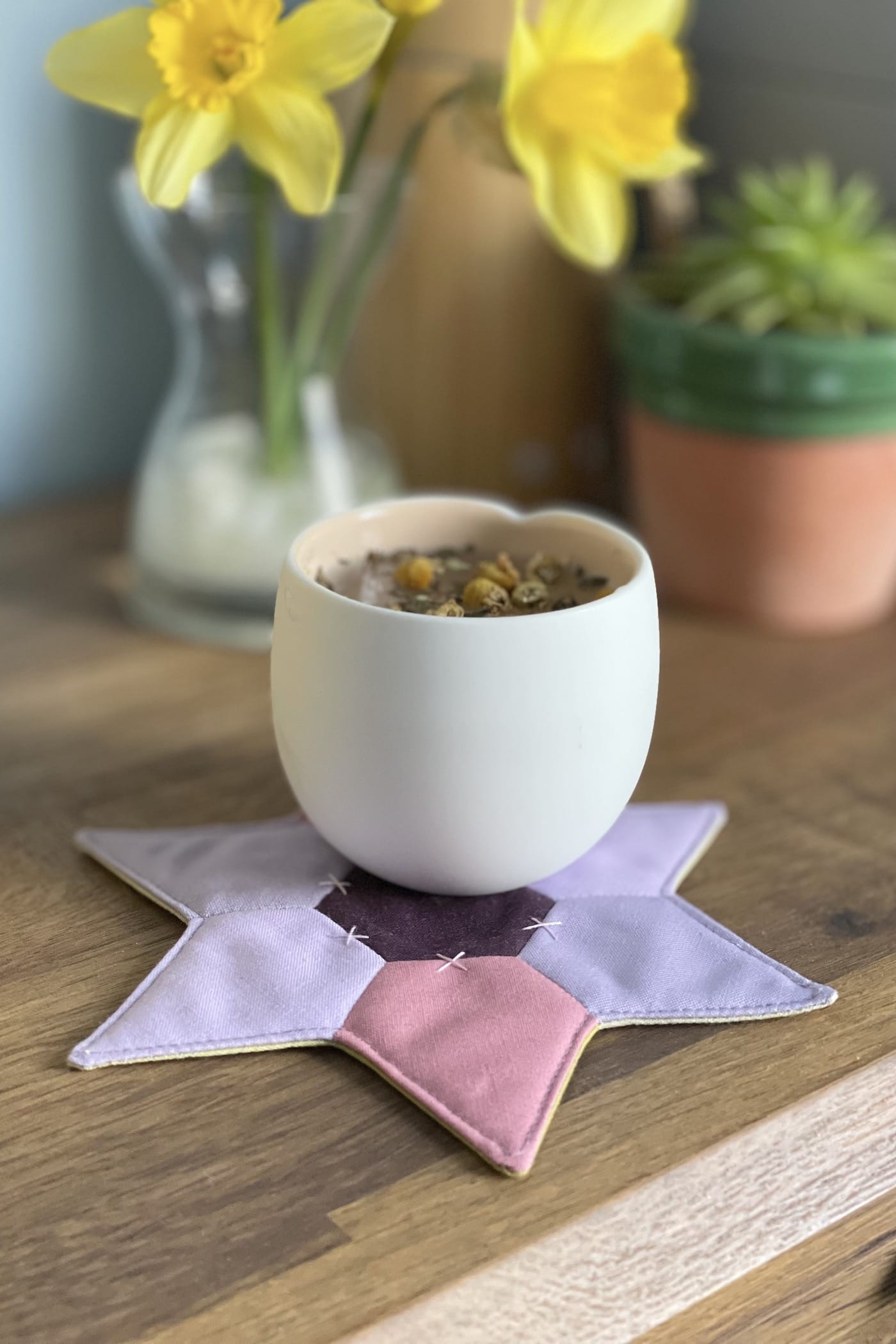 Tapis mug en forme d'étoile avec fleurs et tasse sur table en bois