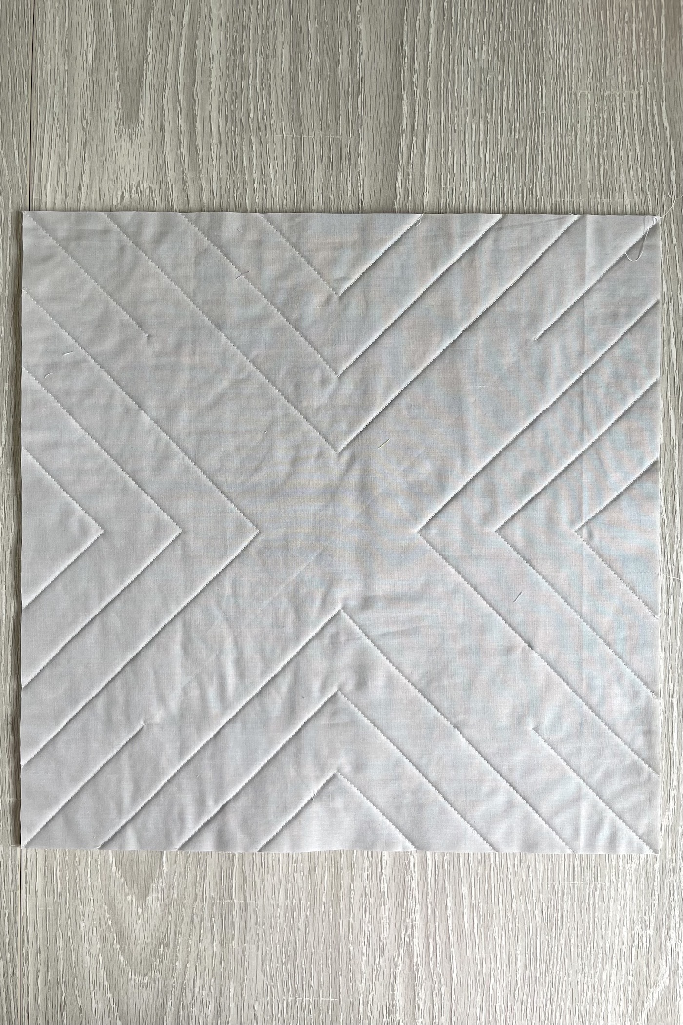 photo détaillée montrant les lignes de courtepointe au dos d'un oreiller en tissu