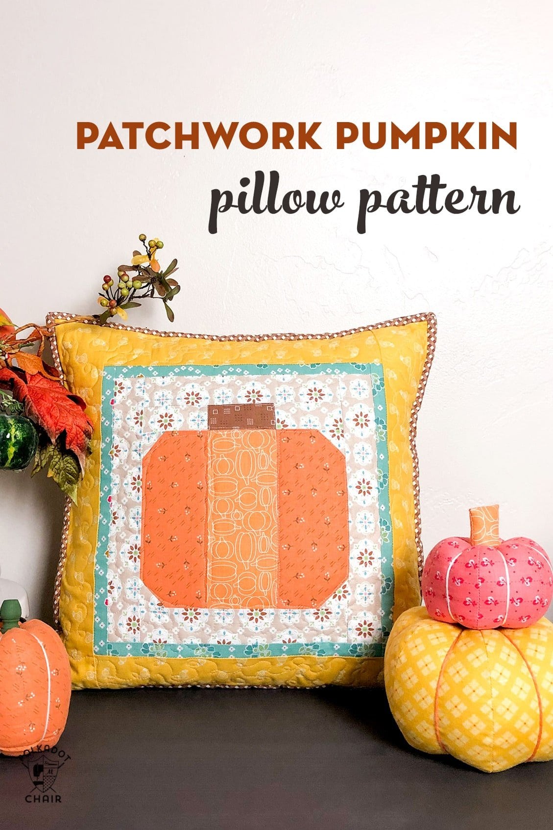 Oreiller citrouille patchwork sur table décorée pour l'automne avec des citrouilles en tissu