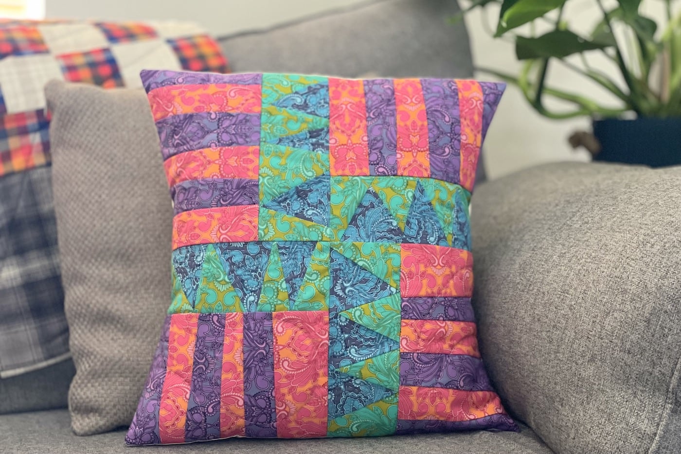Oreiller patchwork bleu, vert, violet et rouge sur le canapé
