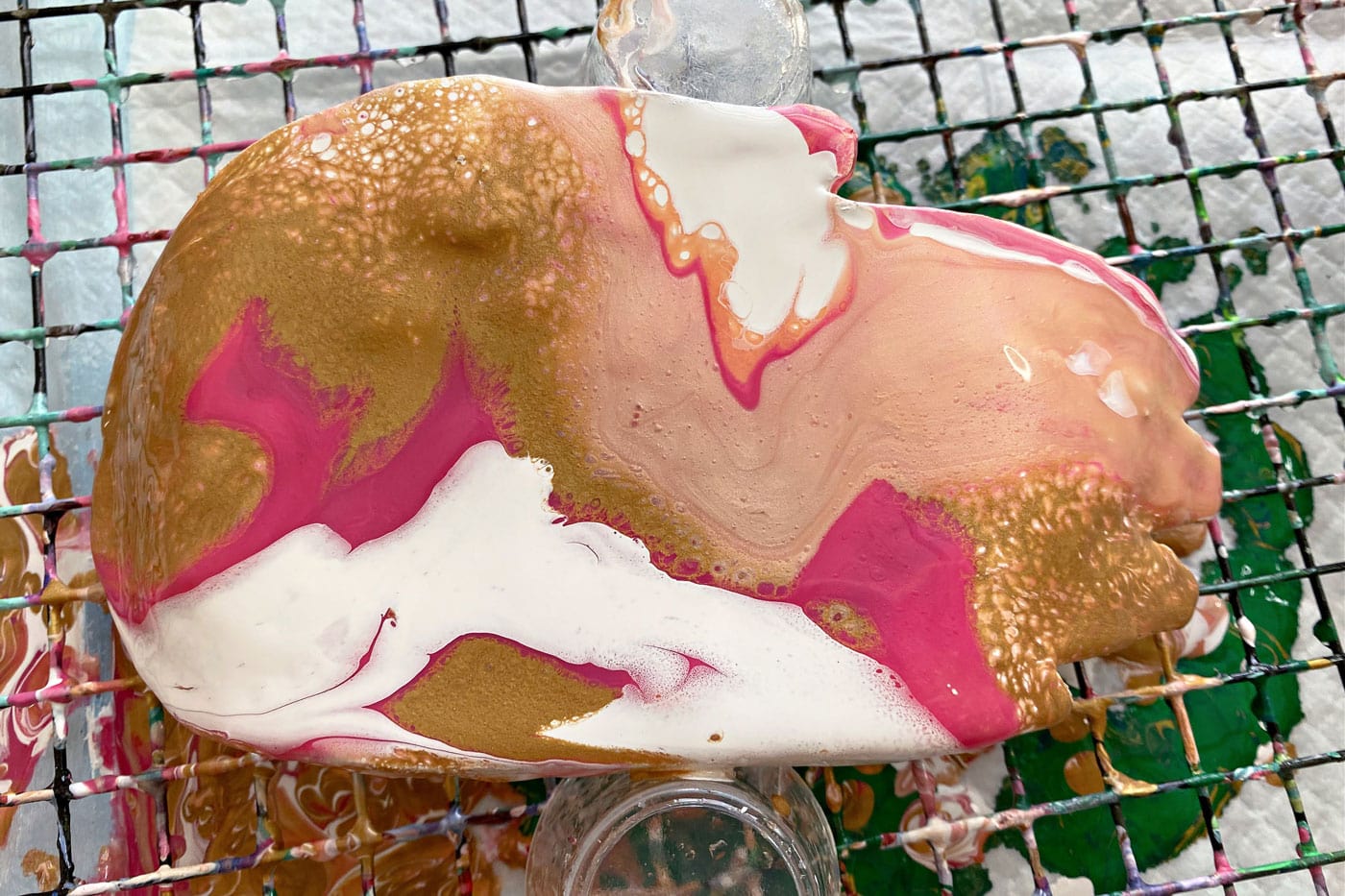 peinture rose, blanche et dorée versée sur le plat