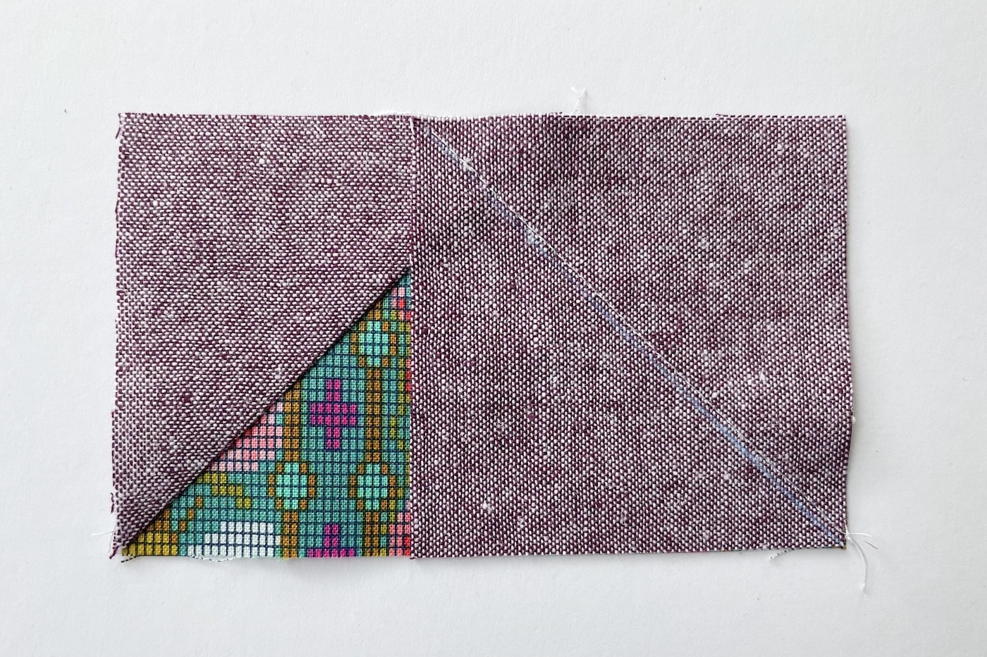 tissu violet et vert sur table blanche découpé en carrés et triangles