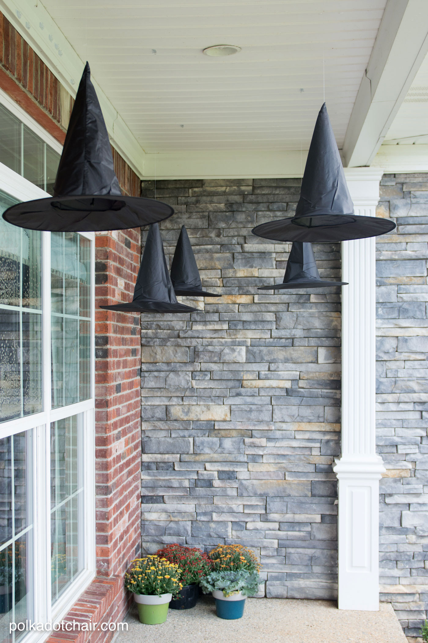 chapeaux de sorcière noirs accrochés au porche. Idée déco astucieuse pour une véranda pour Halloween, les luminaires en chapeau de sorcière flottants, ils s'allument même la nuit !