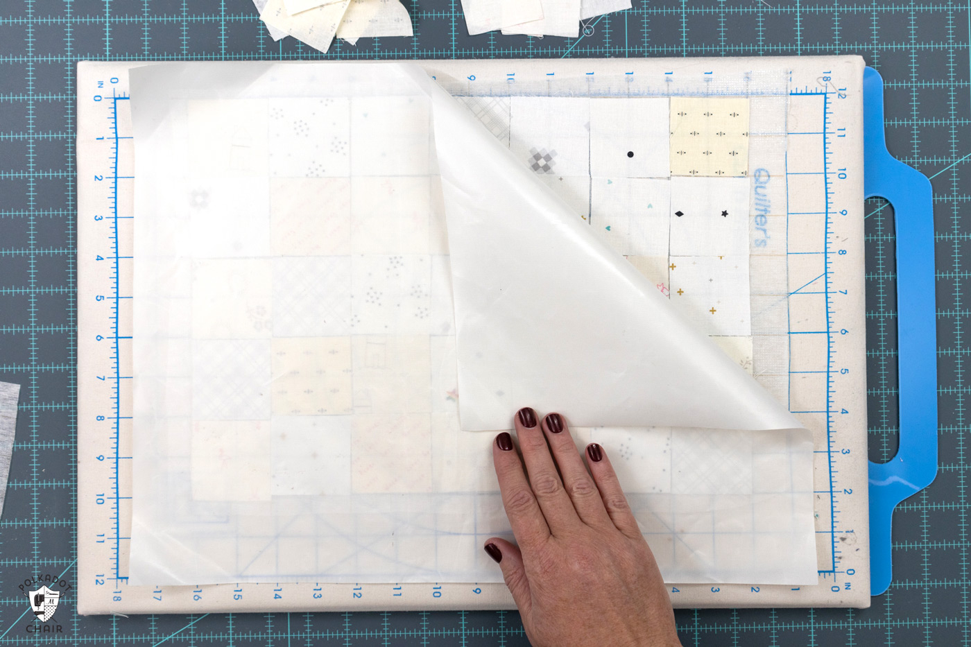 carrés de tissu crème et blancs disposés sur une planche à découper portable avec une feuille de téflon sur le dessus