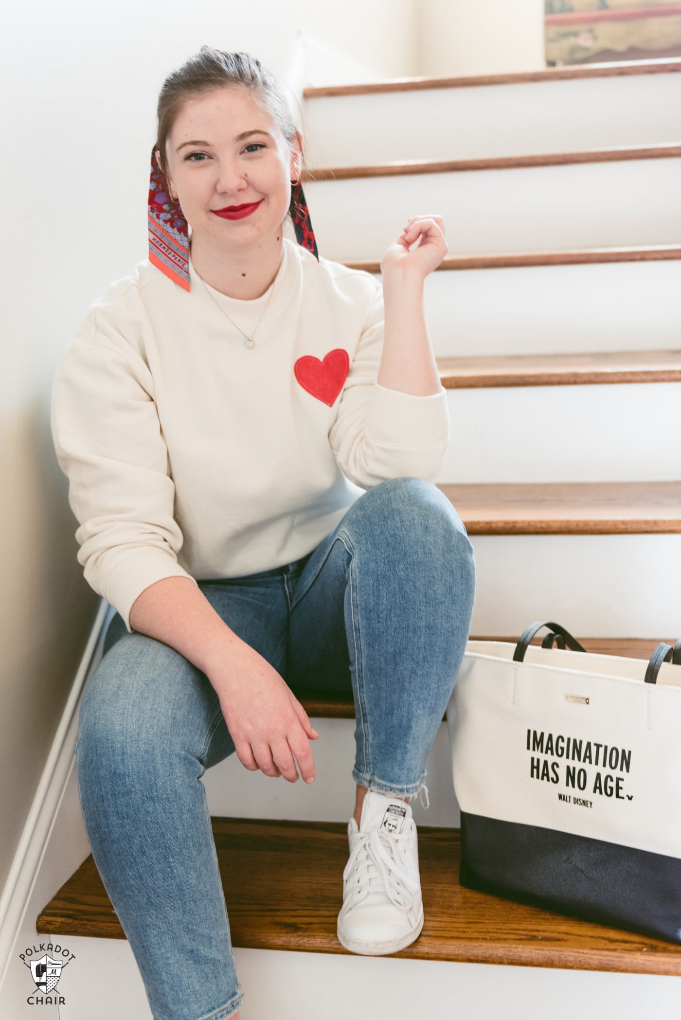 fille en sweat-shirt coeur ivoire assise dans les escaliers