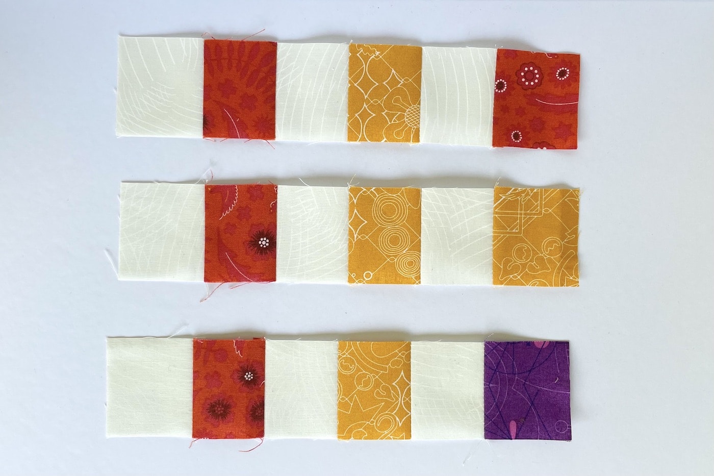 carrés de tissu jaune, violet, vert et rouge