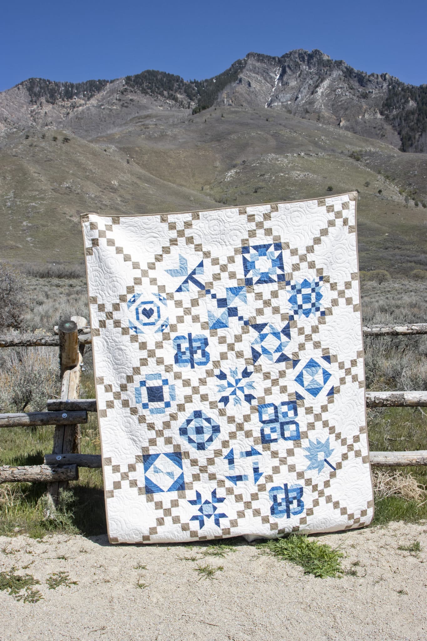 selimut geometris biru, putih dan krem di luar di depan pagar